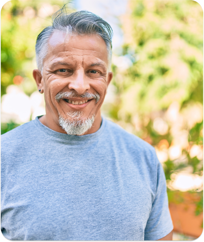 Man looking at the camera and smiling outside.